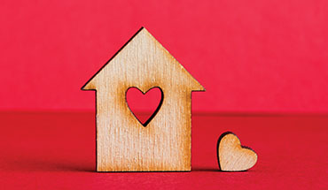 A wooden house standup with a heart block cutout